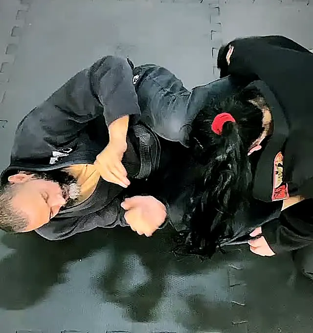 Professora Aninha e Professor Douglas treinando jiu-jitsu no tatame de casa