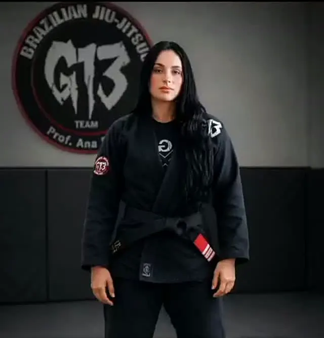 Aninha de quimono preto em frente ao símbolo da G13
